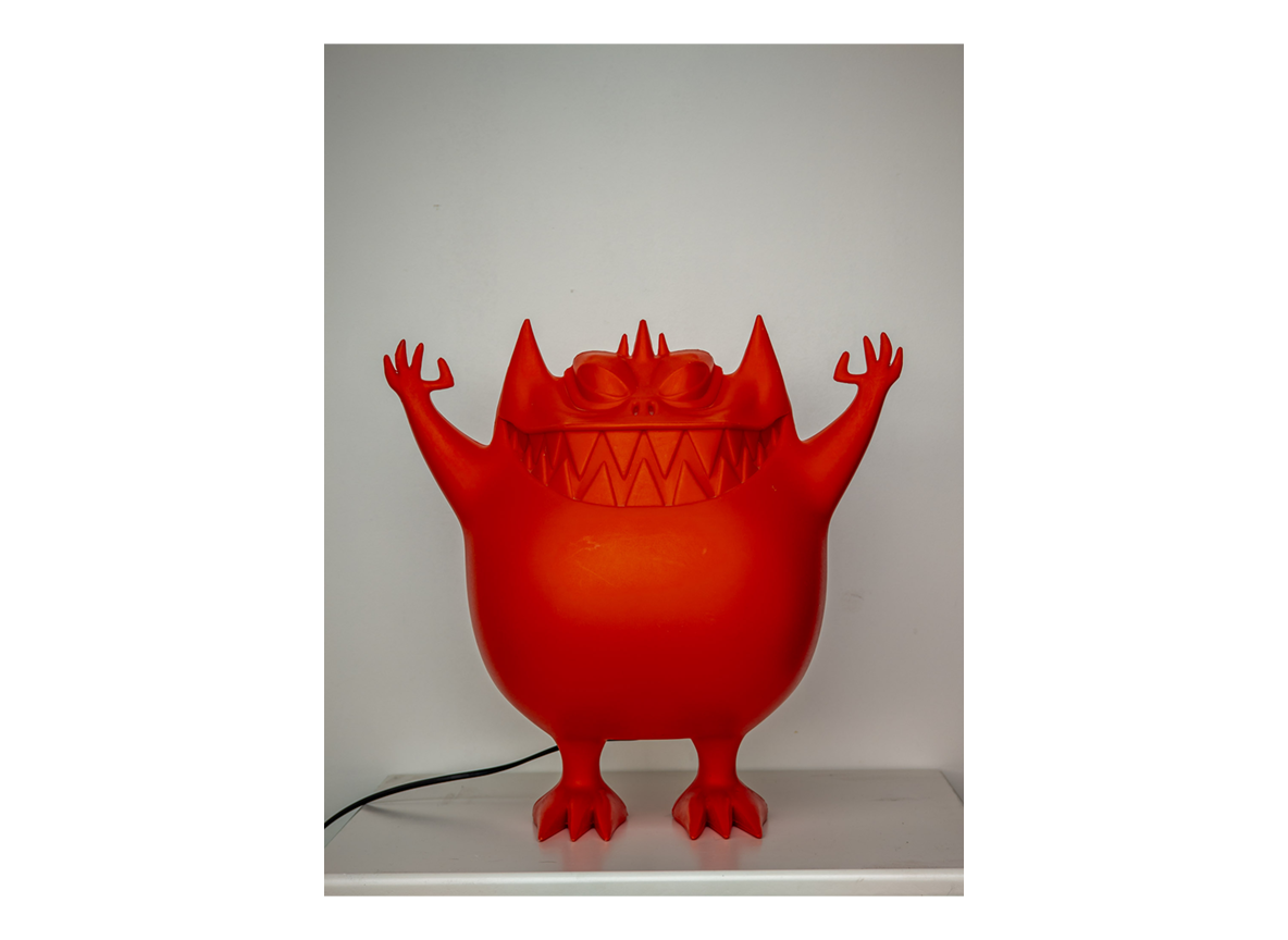 Smartphonefoto van de rode monsterlamp tegen een witte muur
